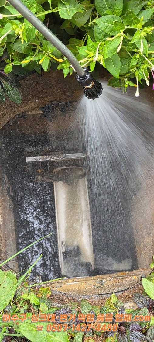 강력한 세척건으로 맨홀 내부를 청소하는 장면